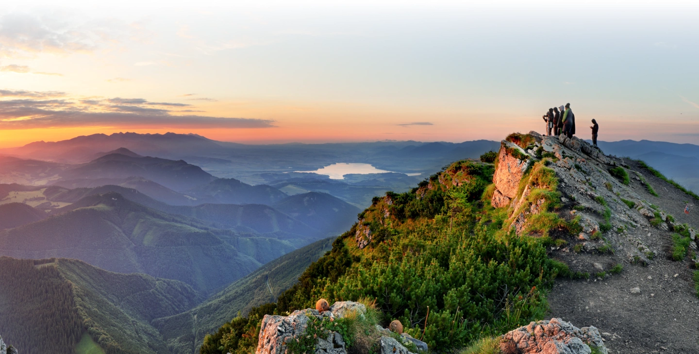Image de montagne sur coucher de soleil. Personnes sur le sommet contemplent le coucher de soleil.